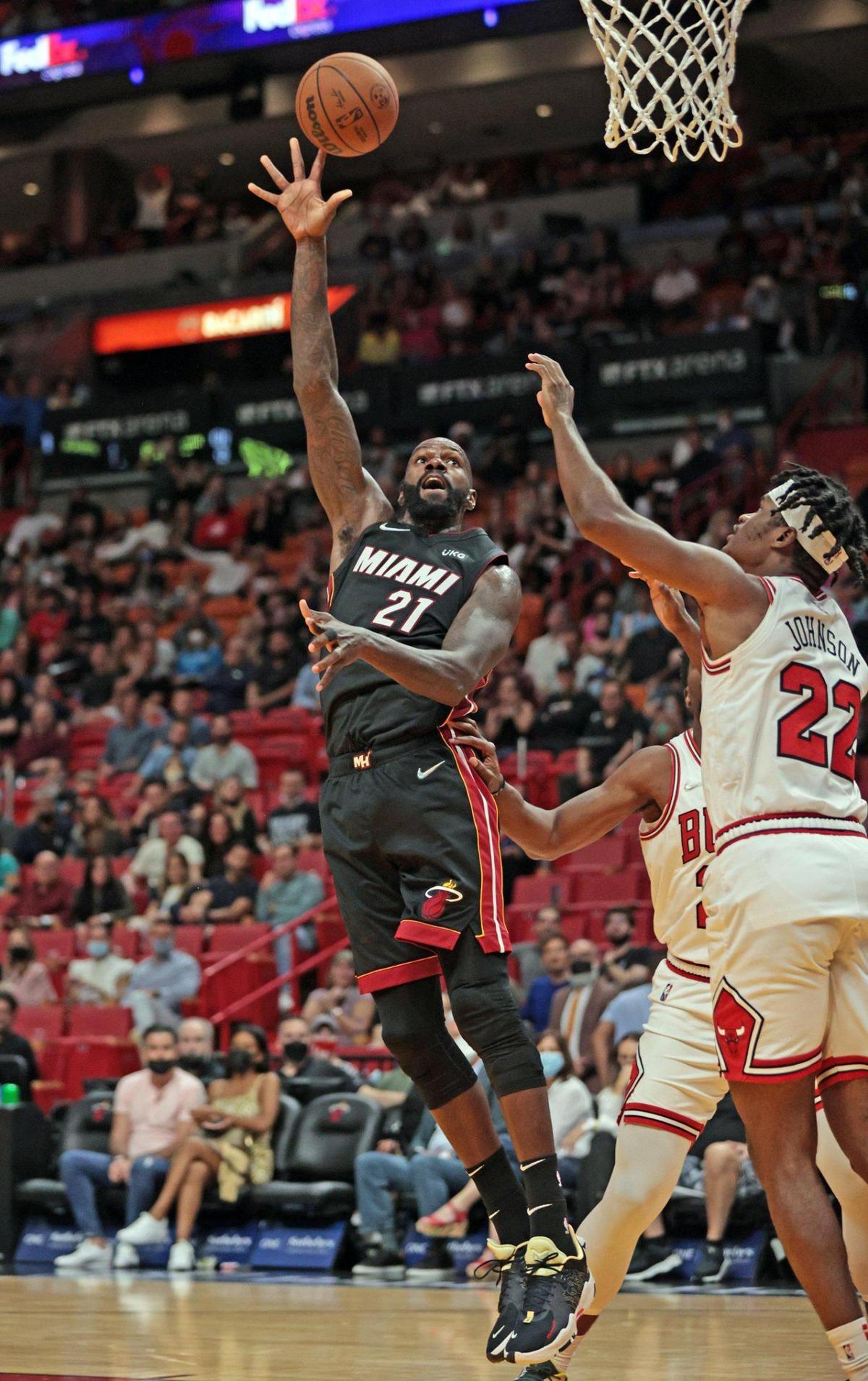 Miami Heat center Dewayne Dedmon (21) attempts a basket as Chicago Bulls forward Alize Johnson (22) and forward Tyler Cook (25) defend in the fourth quarter at the FTX Arena in Miami on Saturday, December 11, 2021.