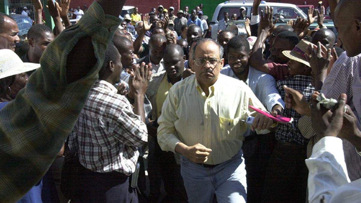 Andre “Andy” Apaid, center in the yellow shirt, a US citizen, climbs the steps of a court house in Port-au-Prince, Haiti, on Thursday, Nov. 27, 2003.