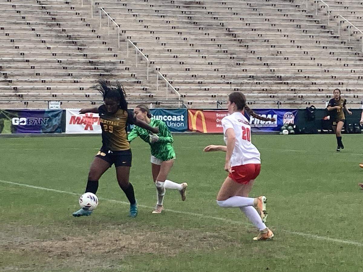 American Heritage’s Ariana Doles (left) breaks through Jacksonville Bishop Kenny’s defense to score the second goal in the Patriots’ state championship win Saturday at Spec Martin Stadium in DeLand, Fla.