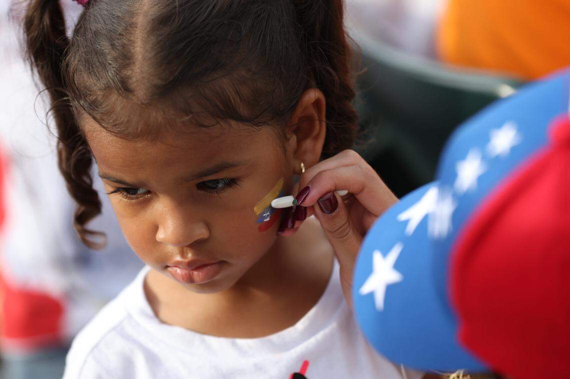 Four year-old Noah Ladera gets a Venezuelan flag face painted on her cheek.