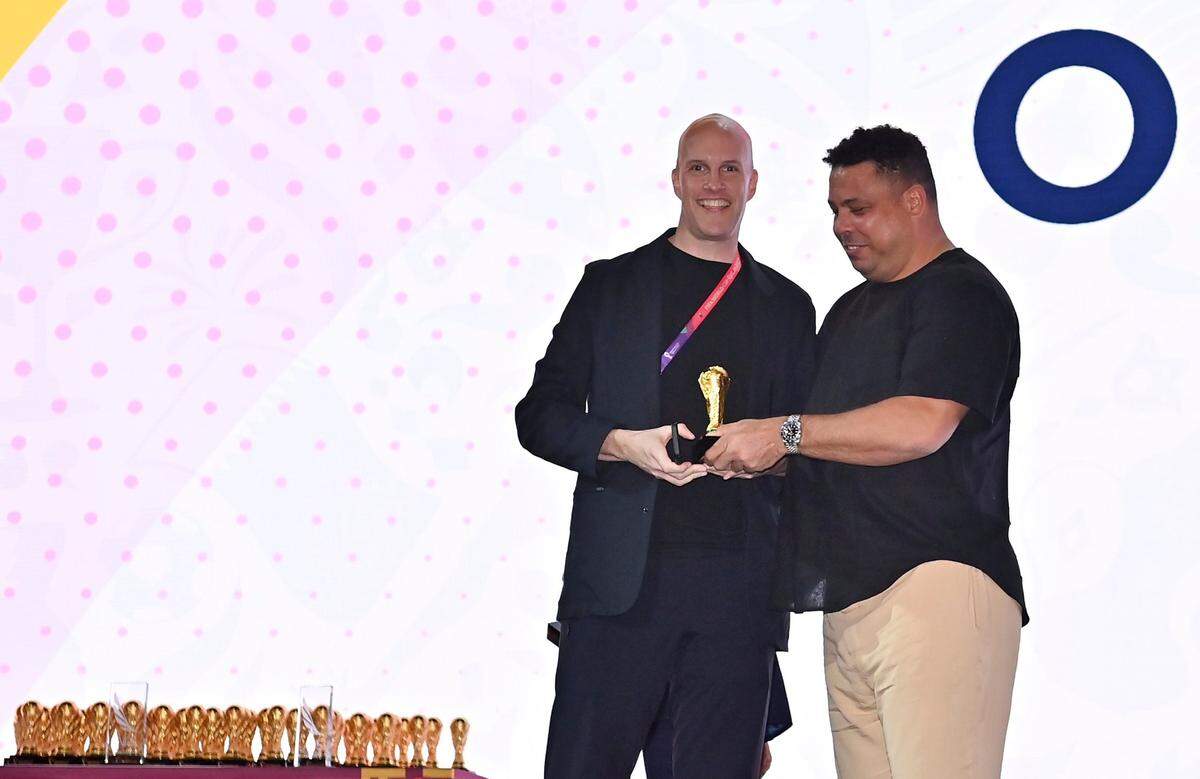Grant Wahl smiles as he is awarded a World Cup replica trophy by soccer legend Ronaldo during an award ceremony in Doha, Qatar on Nov. 29, 2022. Wahl, one of the most well-known soccer writers in the United States, died early Saturday, Dec. 10, 2022, while covering the World Cup match between Argentina and the Netherlands.