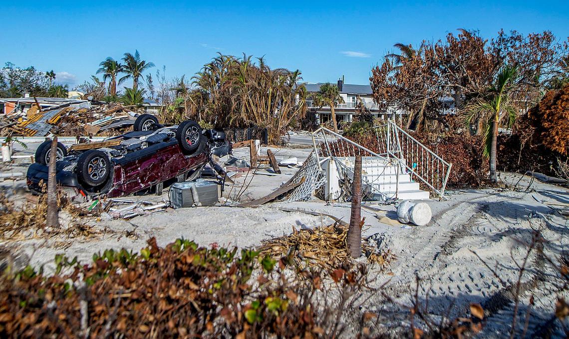 An overturned car and a staircase are among items strewn along Estero Boulevard in Fort Myers Beach Wednesday, Oct. 26, 2022. The area was badly damaged by Hurricane Ian a month earlier.
