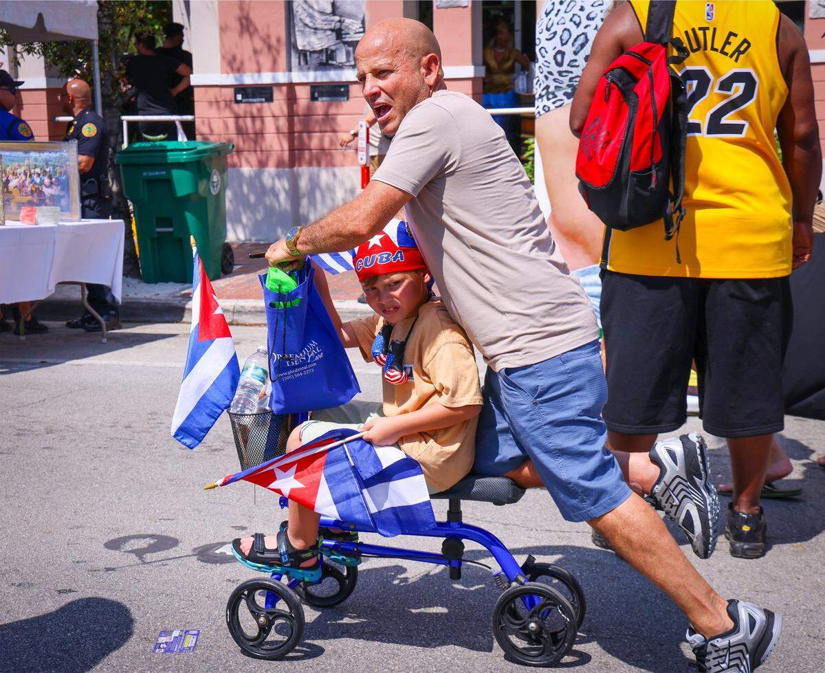 Daniel, 7, and father Nemesio Alvarez, 57, cruise through the crowd.