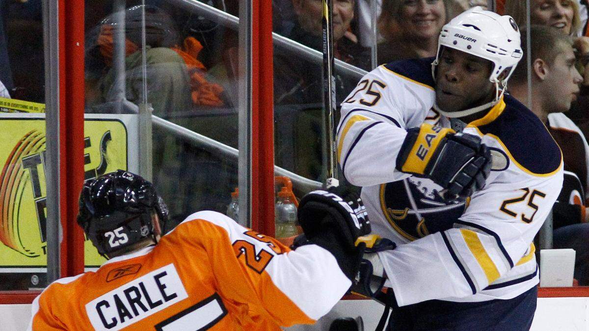 Philadelphia Flyers’ Matt Carle, left, is knocked down by Buffalo Sabres’ Mike Grier in the first period of Game 1 of a first-round NHL hockey playoff series, Thursday, April 14, 2011, in Philadelphia.