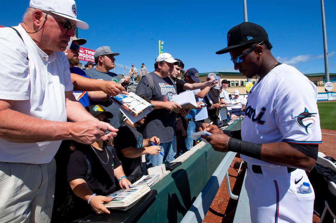Miami Marlins outfielder Lewis Brinson (25) signs memorabilia for fans before the start of a Spring Training game against the Washington Nationals at Roger Dean Chevrolet Stadium in Jupiter, Florida on Sunday, February 23, 2020.