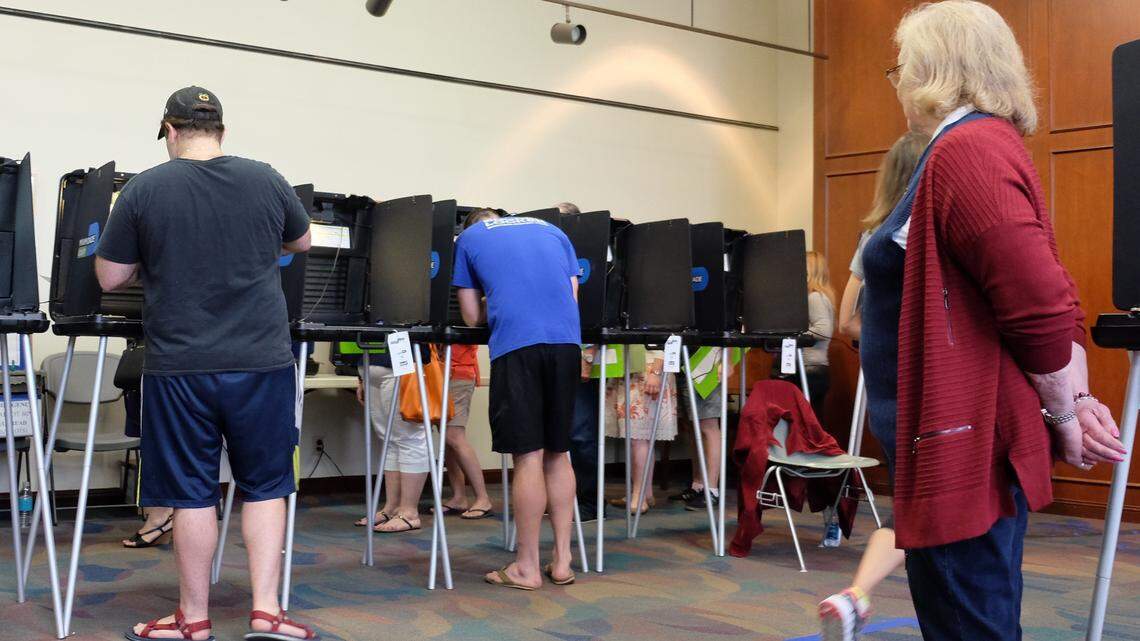 A poll worker keeps an eye on the people voting at the Coral Gables Library during early voting in 2016.