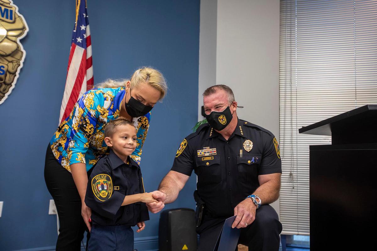 Jeremiah Valera is swon in by North Miami Police Chief Larry Juriga at the North Miami police station on March 20, 2021. His mom Daniela Isaza looks on.