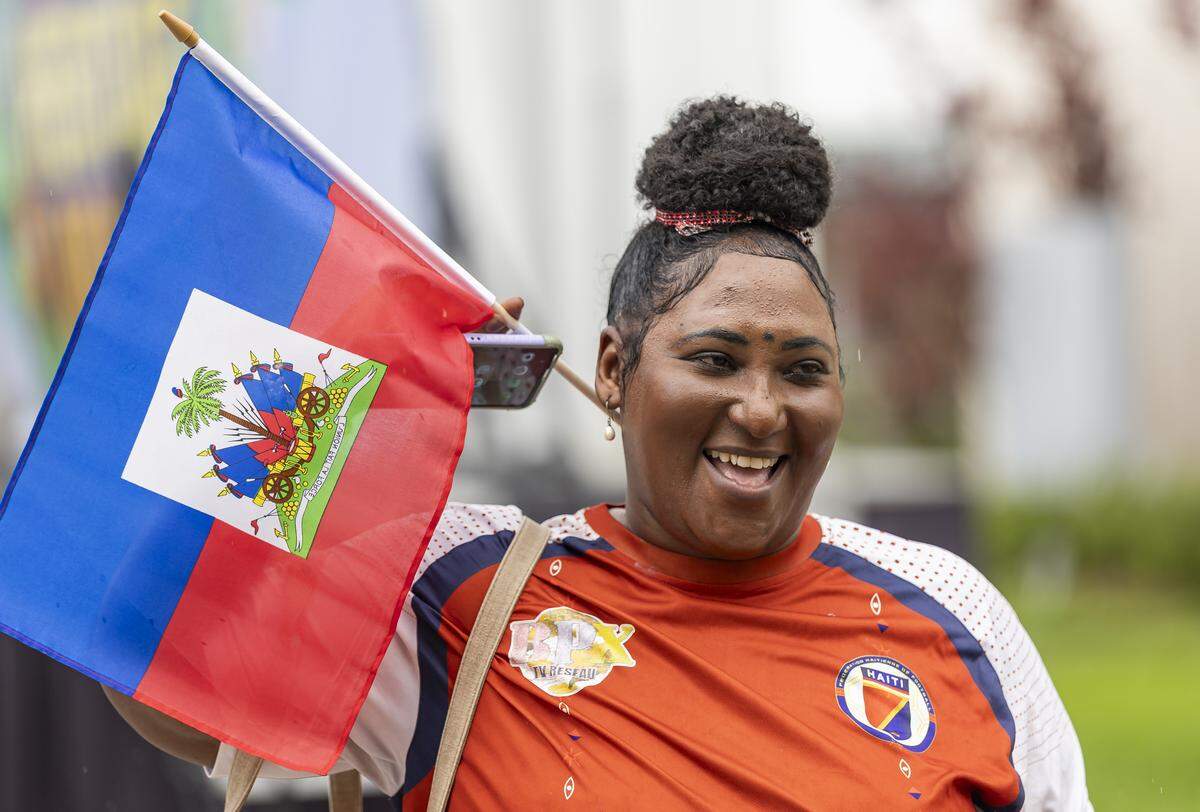 Nadege Etienne holds a Haitian flag while waiting for a meet-and-greet with the Haiti national soccer team at the Museum of Contemporary Art, North Miami on Saturday, May 30, 2026, in North Miami, Fla.