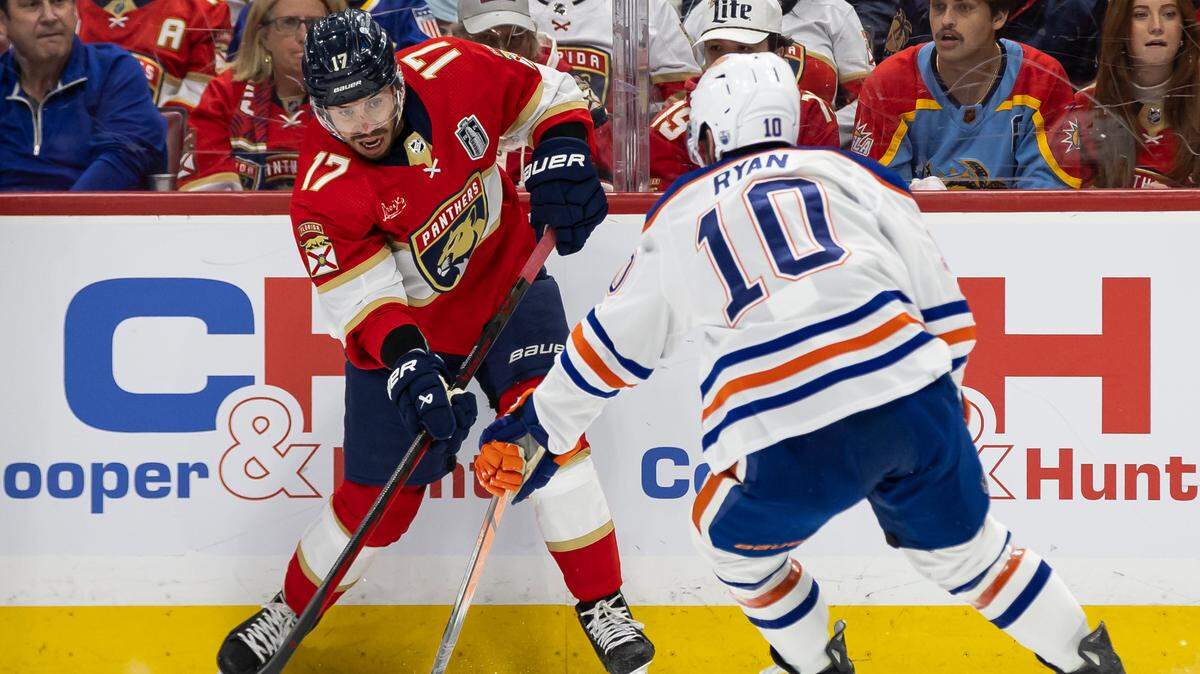 Florida Panthers center Evan Rodrigues (17) looks to pass the puck as Edmonton Oilers center Derek Ryan (10) defends in the first period of Game 5 of the NHL Stanley Cup Final at the Amerant Bank Arena on Tuesday, June 18, 2024, in Sunrise, Fla.