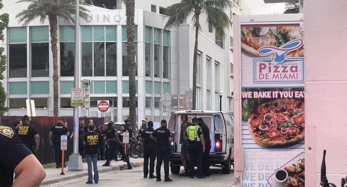 Miami Beach police officers detain a man on Collins Avenue and Sixth Street Saturday.