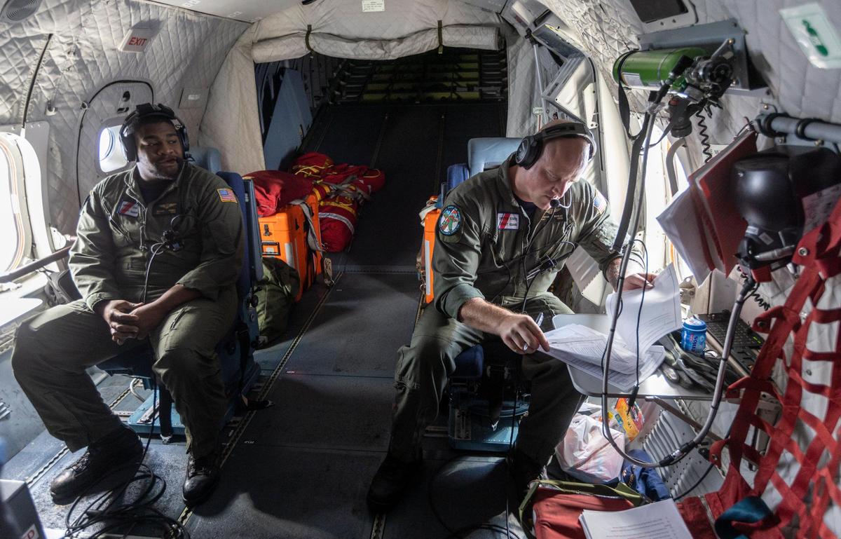 Two members of the crew of a U.S. Coast Guard HC-144 Ocean Sentry airplane while on a reconnaissance flight over the Florida Straits and the Bahamas on Friday, April 22, 2022.