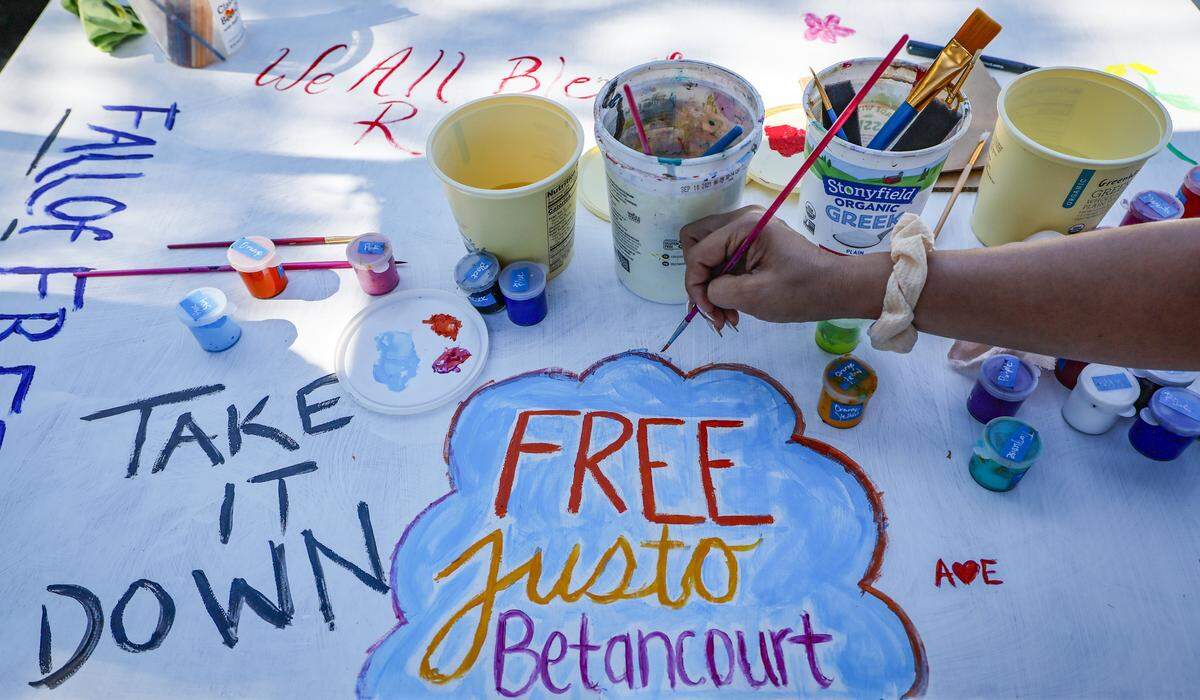 Arianne Betancourt paints a May Day Art Mural Painting  during a May Day Rally outside of Alligator Alcatraz located at the Dade-Collier Training and Transition Airport in the Florida Everglades, Ochopee, Florida, on Friday, May 1, 2026. Her father,  Justo Betancourt, currently being detained at Alligator Alcatraz.