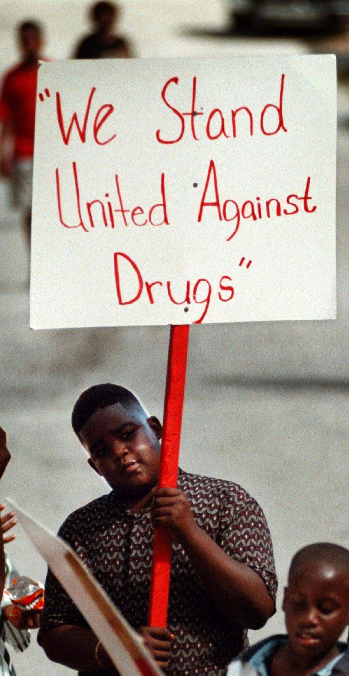 A photo from the Miami Herald archives from Oct. 26, 1997 of a young man holding a sign during a red ribbon parade in the Liberia neighborhood.
