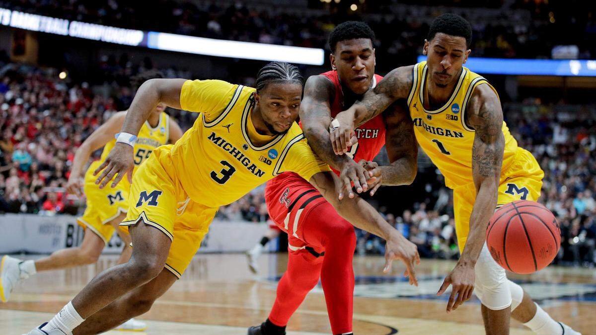 Texas Tech forward Deshawn Corprew, middle, reaches for a loose ball between Michigan guard Zavier Simpson, left, and guard Charles Matthews during the first half an NCAA men’s college basketball tournament West Region semifinal Thursday, March 28, 2019, in Anaheim, Calif.