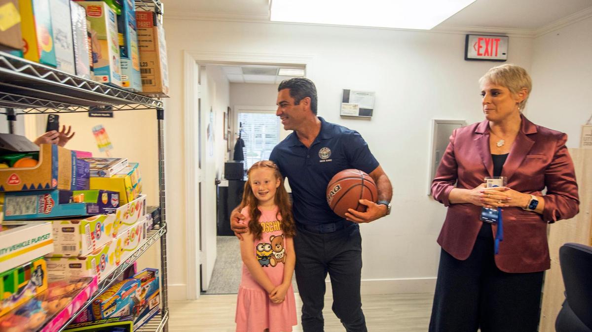 (L) Nicole Rodriguez, 8 years old, with (C) Miami Mayor Francis Suarez when they bring gifts for children at Kristi House, an organization that provides treatment for children who have experience trauma at Kristi House, Miami, on Wednesday December 21st., 2022. (R) Amanda Altman, CEO Kristi House.