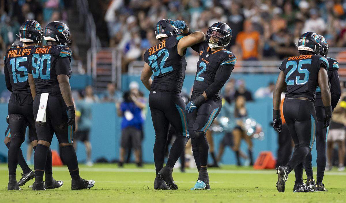 Miami Dolphins defensive tackle Zach Sieler (92) celebrates with outside linebacker Bradley Chubb (2) after they stopped a play against the New York Jets in the second half of their NFL game at Hard Rock Stadium on Monday, Sept. 29, 2025, in Miami Gardens, Fla.