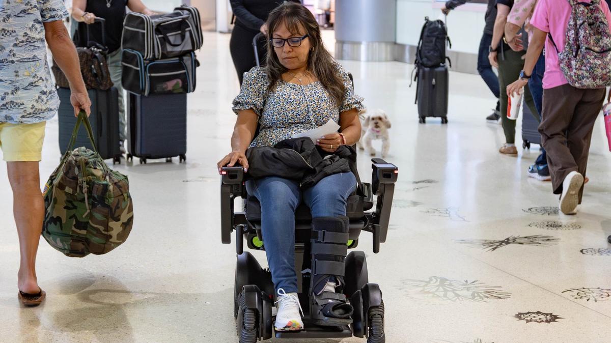 Sandra Gasca, 55, rides on a WHILL autonomous wheelchair before her American Airlines flight in Concourse D at Miami International Airport on Friday, June 21, 2024 in Miami, Fla.