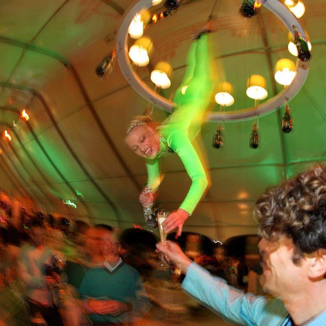Champagne is poured by woman attached to chandelier at the 2010 BubbleQ at the South Beach Wine & Food Festival.