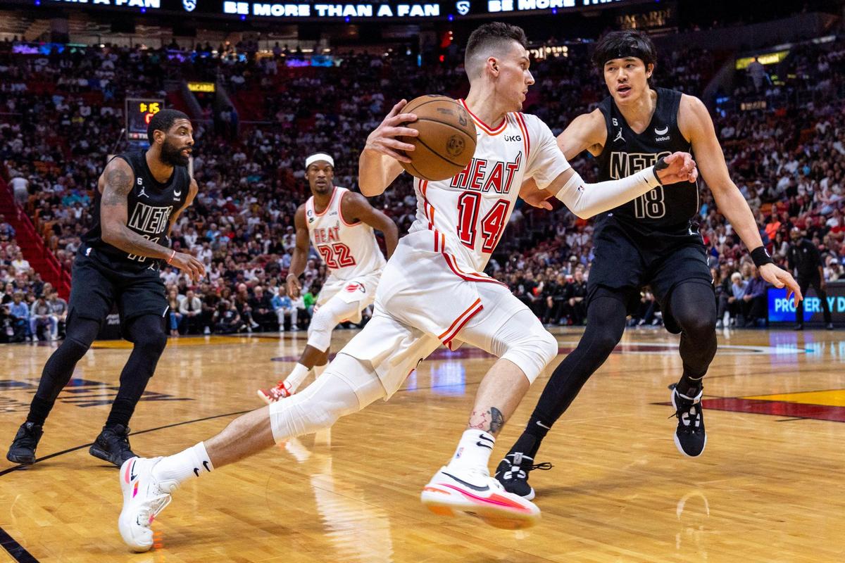 Miami Heat guard Tyler Herro (14) drives on Brooklyn Nets forward Yuta Watanabe (18) during the first half of an NBA game at FTX Arena in Downtown Miami, Florida, on Sunday, January 8, 2023.