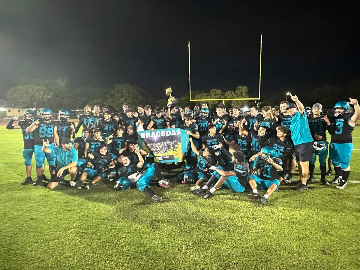 The Coral Reef football team celebrates after their 14-7 victory over Ferguson on Thursday night at Miami Southridge High. The Barracudas won their second GMAC Independent Schools championship in the past three seasons.