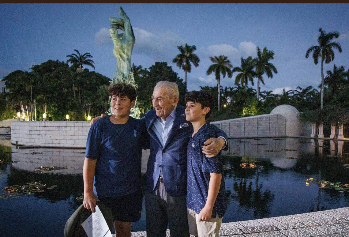 Blake Kandell (left) and Nate Pelz, greet Holocaust survivor David Schaecter, at the Holocaust Memorial Miami Beach on Nov. 5, 2023.