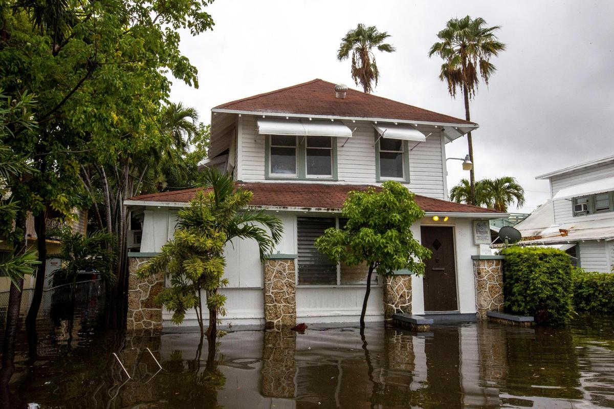 A house’s lawn is submerged under floodwaters off Southwest Third Street and Eighth Avenue in the Little Havana neighborhood of Miami, Florida, on Saturday, June 4, 2022. Lower homes like these are more at risk from flooding from sea level rise and nearby development at higher elevations.