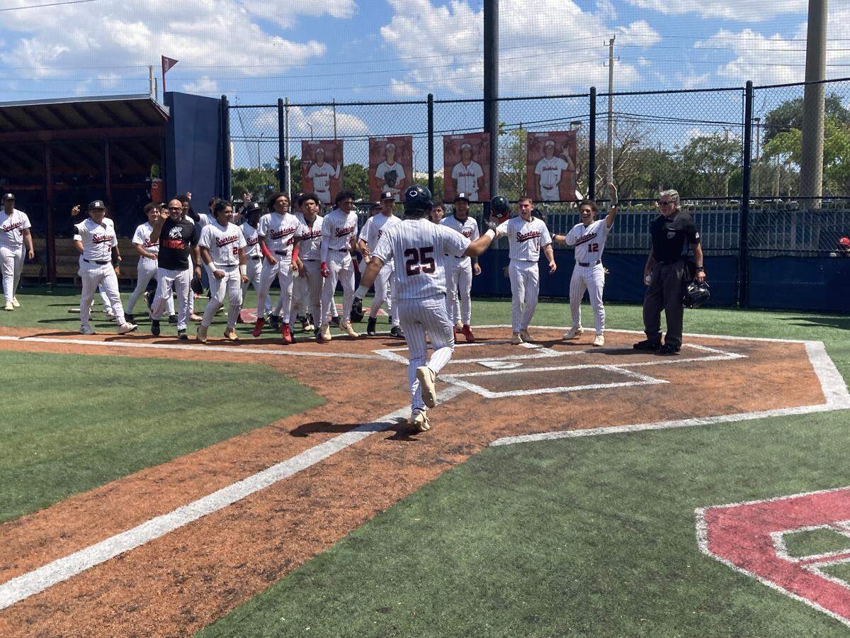 Southridge’s Jonathan Paniagua is greeted at the plate by his teammates following his walk-off grand slam in the bottom of the fifth of the decisive game of the Region 4-6A semifinal at Doral Academy.