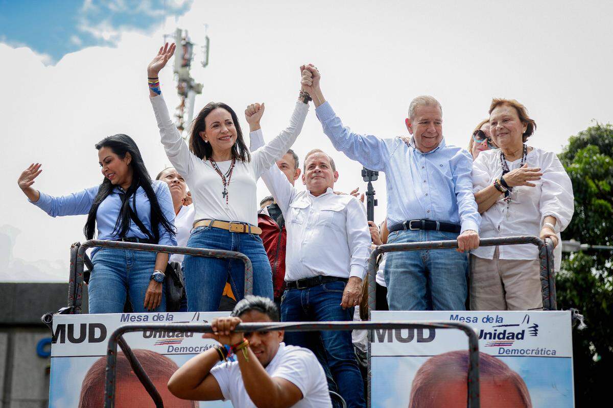30 July 2024, Venezuela, Caracas: Maria Corina Machado (M, l), opposition leader, and Edmundo Gonzalez Urrutia (M, r), opposition presidential candidate, raise their fists as they drive a car through a demonstration against the official results of the presidential election. Photo: Jeampier Arguinzones/dpa/Sipa USA