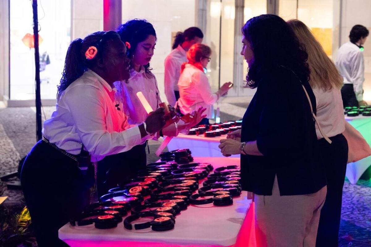 Guides assign color-coded headphones to audience members outside the Colony Theatre for Miami New Drama’s “Lincoln Road Hustle.”