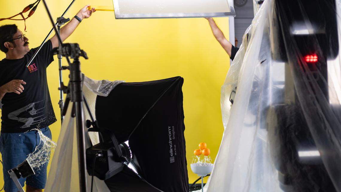 Francisco Aguila, founder of Miami Cinema Robot, uses a launcher to throw the oranges into the air and a catapult to toss the water at the airborne oranges during a demonstration in his studio on Aug. 9, 2023.