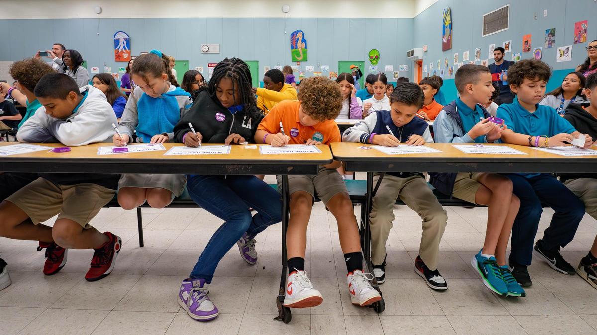 Fifth-grade students at Edward L. Whigham Elementary School write their names on certificates on Nov. 14, 2024, in Cutler Bay.