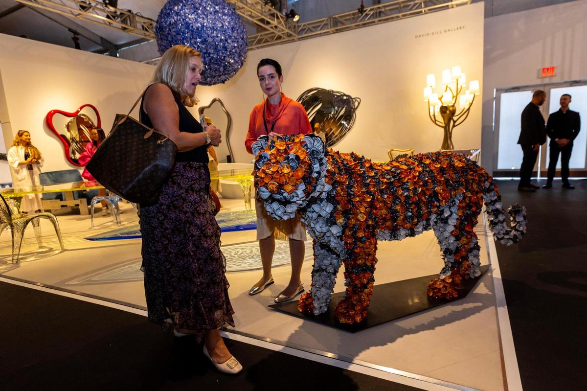 Two woman discuss a piece of artwork at the David Gill Gallery during the VIP opening of Design Miami for Art Basel in Miami Beach, Florida, on Tuesday, December 5, 2023.