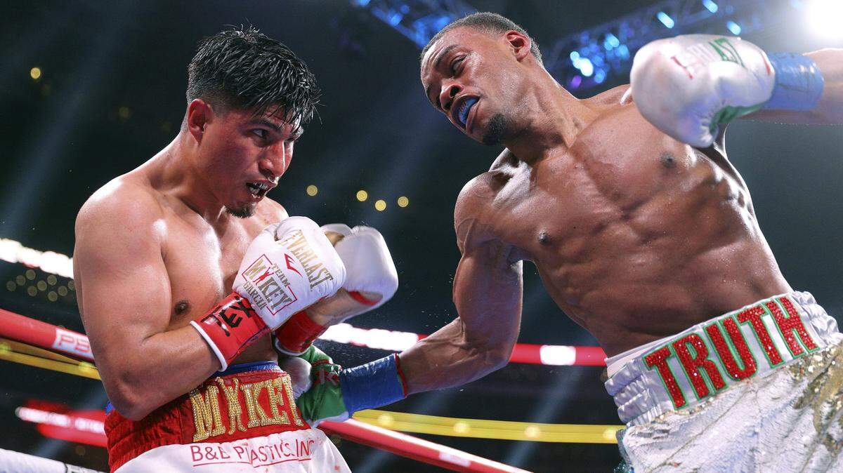 Mikey Garcia, left, takes a blow to the body from Errol Spence Jr. during the ninth round of the IBF welterweight championship boxing bout Saturday, March 16, 2019, in Arlington, Texas. (AP Photo/Richard W. Rodriguez)