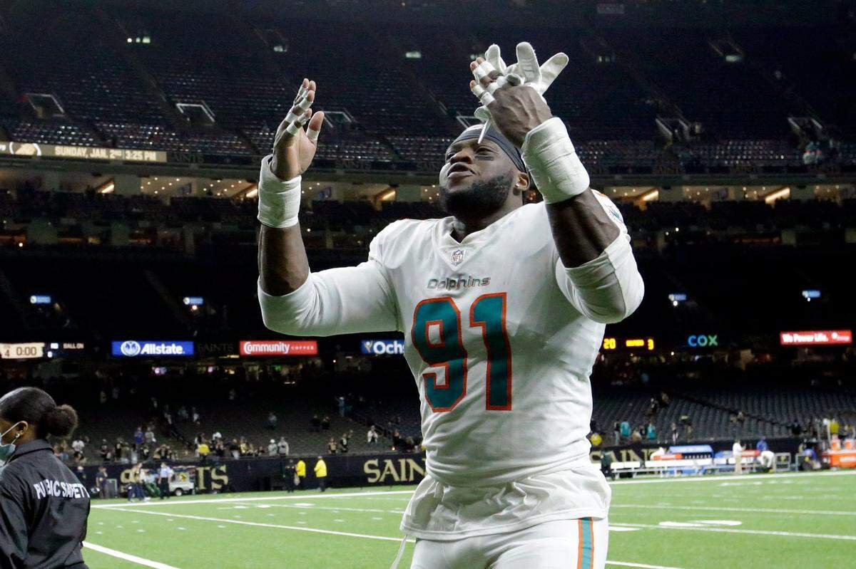 Miami Dolphins defensive end Emmanuel Ogbah (91) celebrates after an NFL football game against the New Orleans Saints Monday, Dec. 27, 2021, in New Orleans. The Dolphins won 20-3. (AP Photo/Butch Dill)