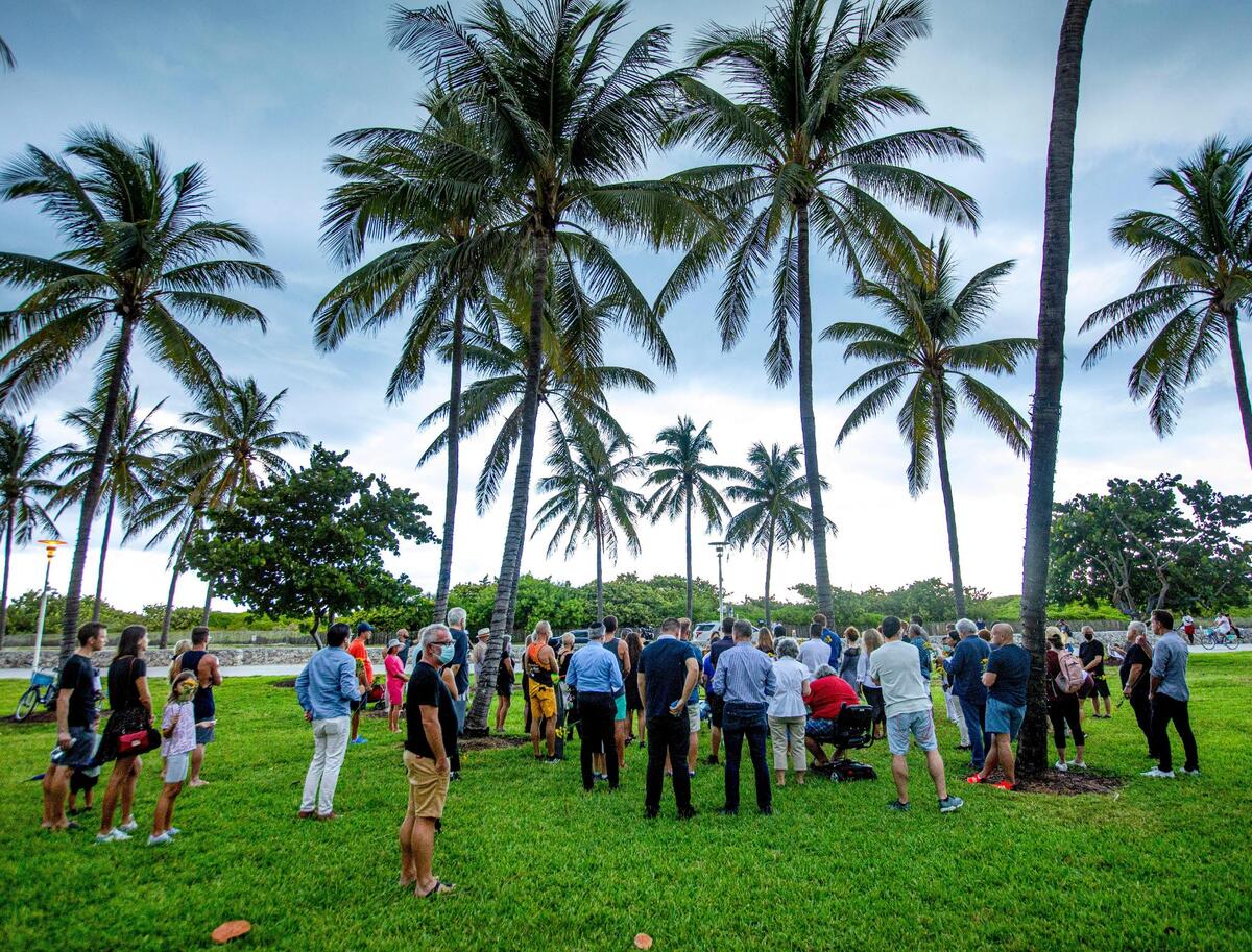 People gather at Lummus Park during a vigil for Dustin Wakefield, who was dining on Ocean Drive when he was fatally shot.