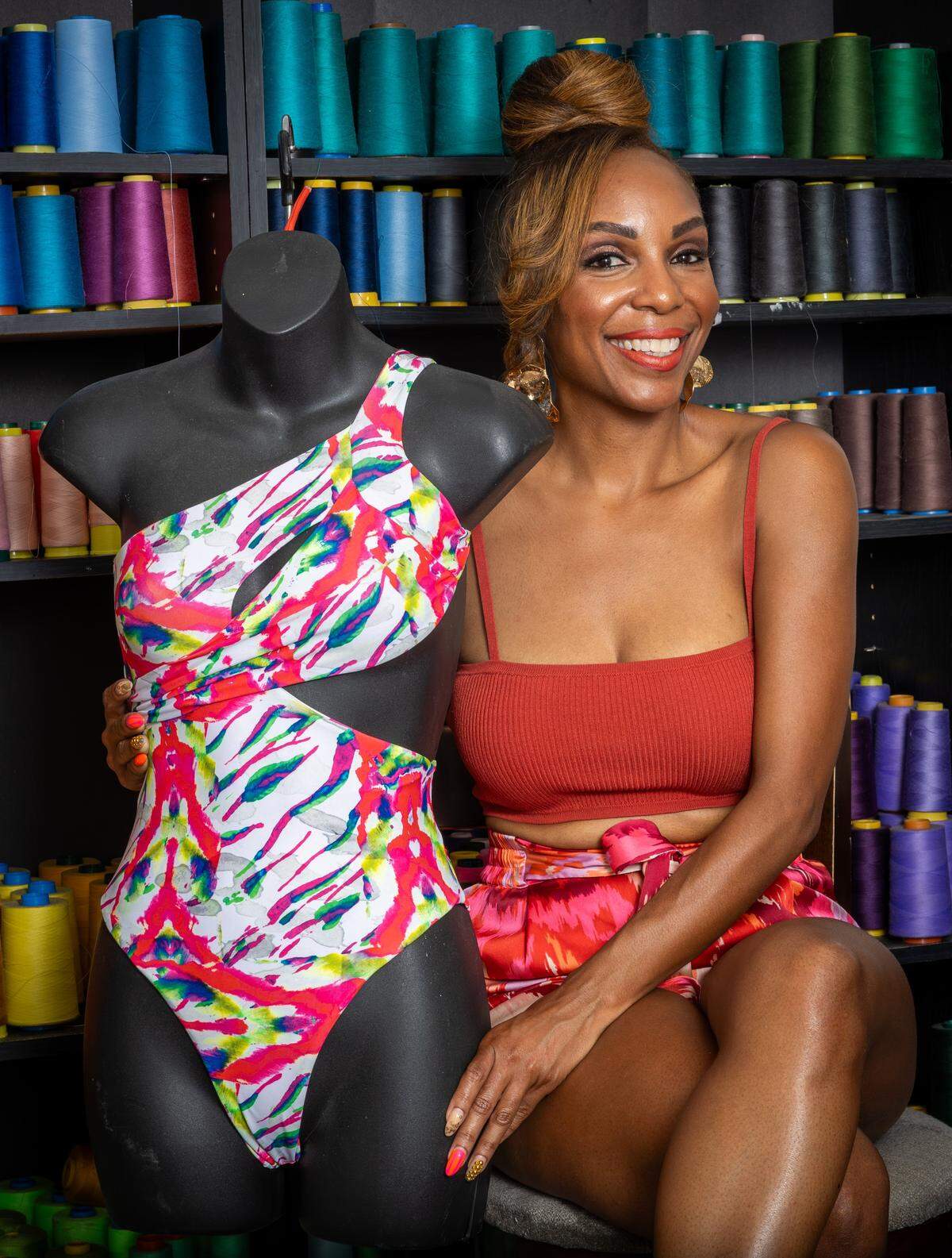 Keva Johnson, a swimsuit designer from Miramar, poses with one of her swimsuites in her head seamstress's studio on Wednesday, May 27, 2026, in Miami, Fla.