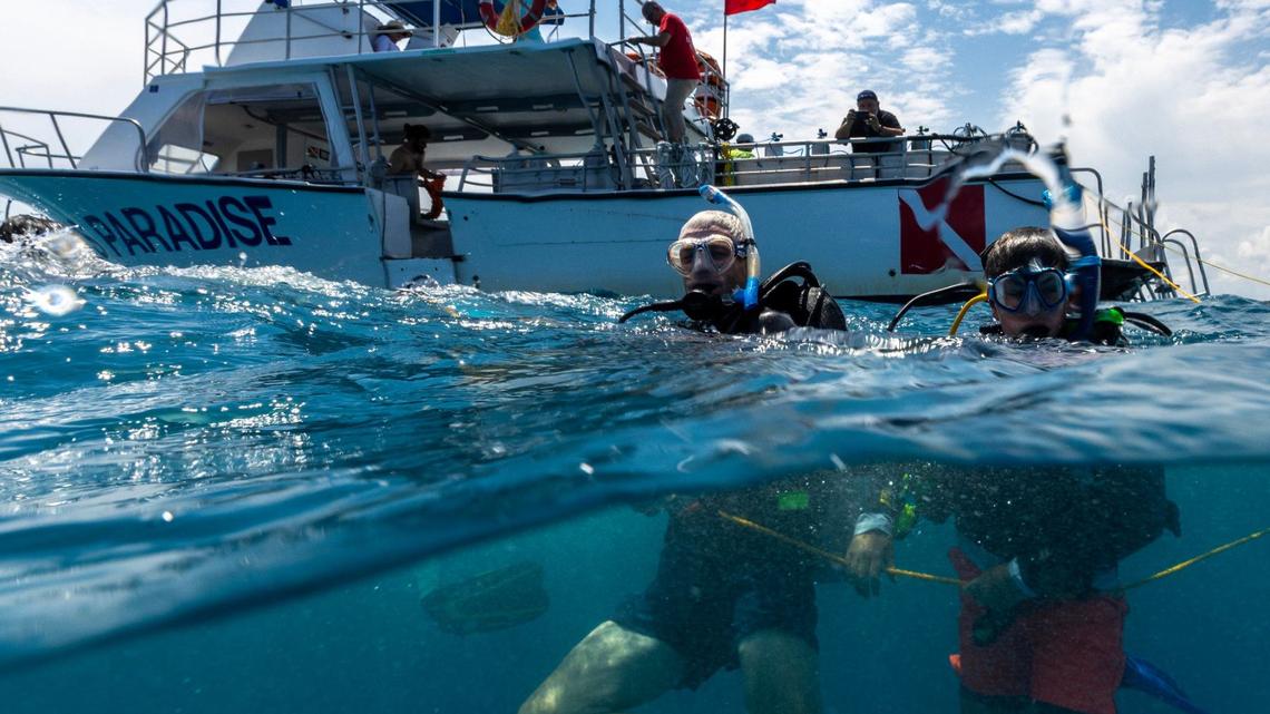 Master Diver Matteo Miller, 12, right, and his father Paul Miller, left, tread water before an ocean dive session on Thursday, August 8, 2024, in Key Biscayne, Fla. Miller received the Master Diver certification after completing his Rescue diver certification.