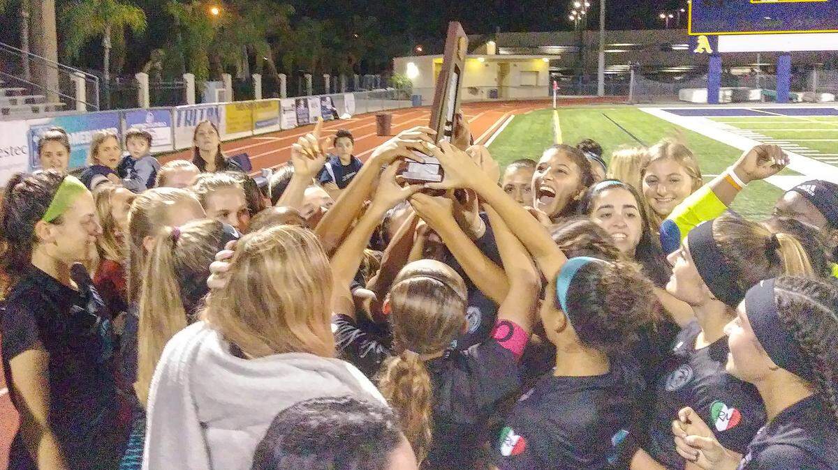 The Archbishop McCarthy girls’ soccer team holds up their district championship trophy after defeating St. Thomas Aquinas on Thursday, Jan. 31, 2019
