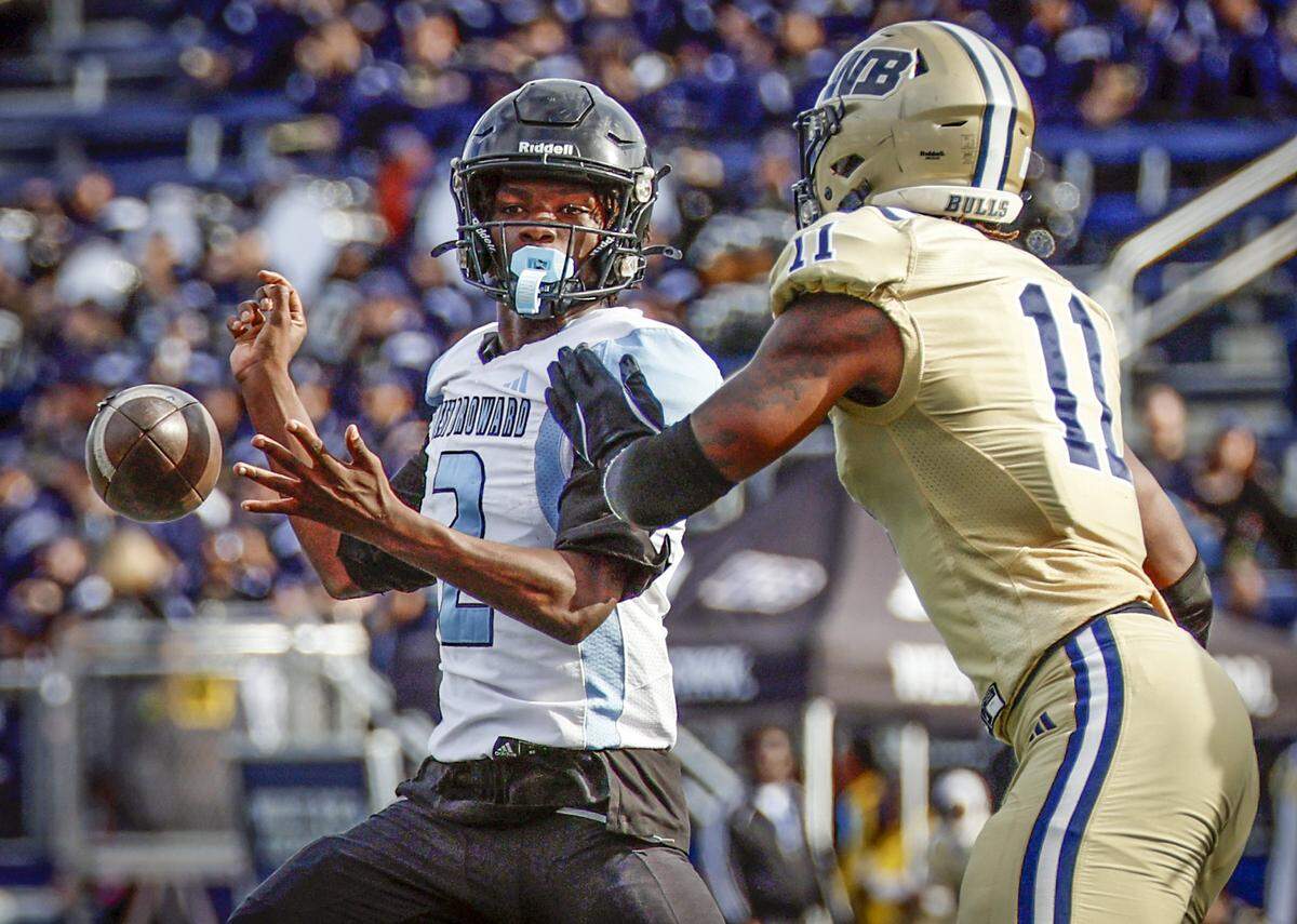 West Broward Bobcats quarterback Brandin Mincy (2) fumbles the ball as West Boca Bulls defensive end Demetrius Geathers Jr. (11) defends late in the fourth quarter during Class 6A, Region 3 State Championship football game at FIU's Pitbull Stadium in Miami, Florida on Friday, December 12, 2025.