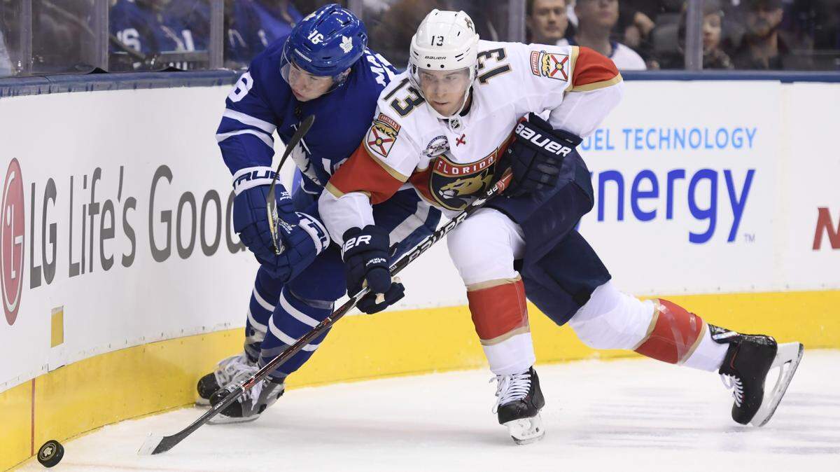 Toronto Maple Leafs right wing Mitchell Marner (16) and Florida Panthers defenseman Mark Pysyk (13) compete for the puck during the first period of an NHL hockey game Thursday, Dec. 20, 2018, in Toronto.