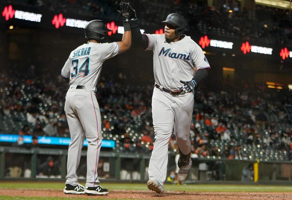 SAN FRANCISCO, CALIFORNIA - APRIL 24: Jesus Aguilar #24 of the Miami Marlins is congratulated by Magneuris Sierra #34 after hitting a two-run home run against the San Francisco Giants in the ninth inning at Oracle Park on April 24, 2021 in San Francisco, California. (Photo by Thearon W. Henderson/Getty Images)