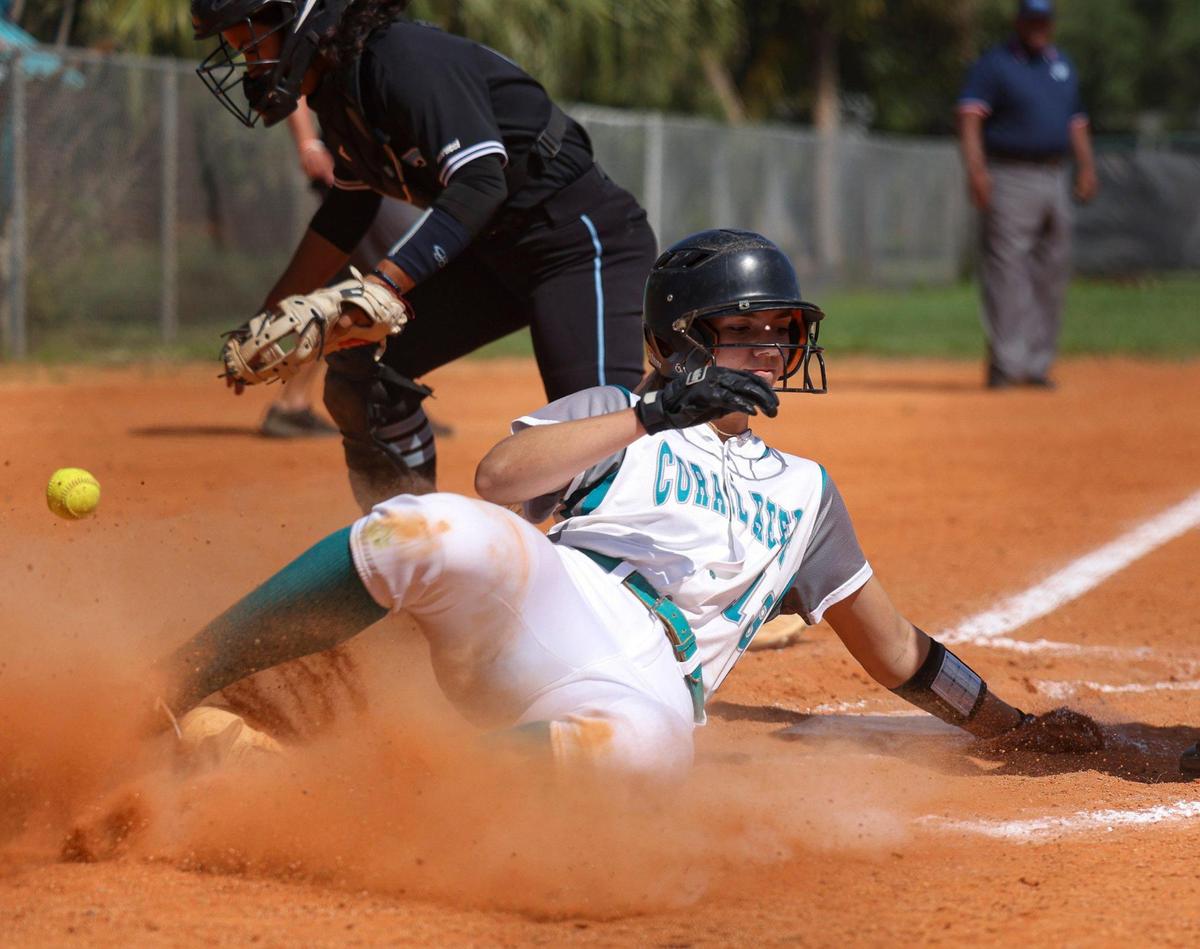 Coral Reef’s Rachel Hawkins (13) slides into home plate during the first inning of the Greater Miami Athletic Conference softball final against Palmetto on Thursday, April 20, 2023, at Coral Reef High School in Richmond Heights, Fla. Coral Reef won 5-2.