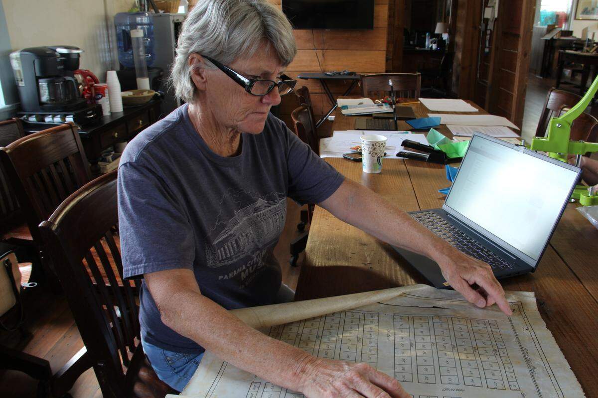 Nancy Hudson of the Historic St. Andrews Waterfront Partnership board of directors examines the original 1913 plat map for Balboa Cemetery on April 26, 2022. Using this map and records from the Bay County property appraiser, Hudson was able to map on her computer approximately where the cemetery used to be. 