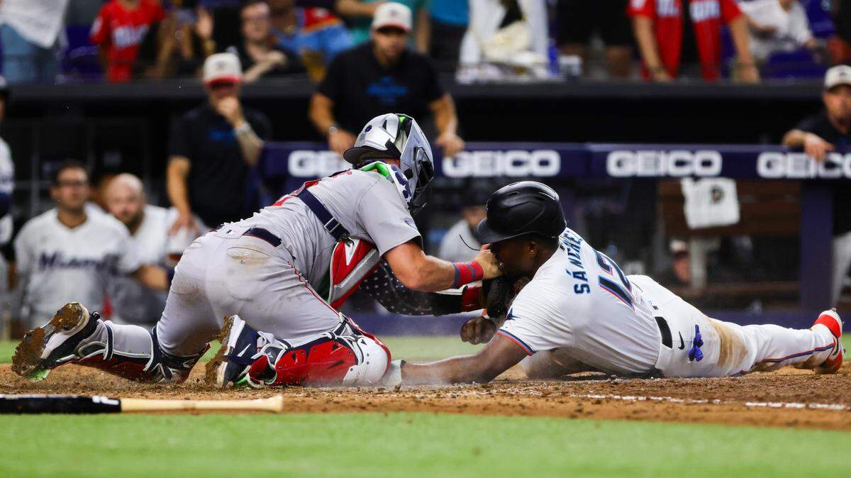Jul 4, 2024; Miami, Florida, USA; Miami Marlins right fielder Jesus Sanchez (12) slides at home plate but cannot score against Boston Red Sox catcher Reese McGuire (3) on a throw by left fielder Jarren Duran (not pictured) during the ninth inning at loanDepot Park. Mandatory Credit: Sam Navarro-USA TODAY Sports