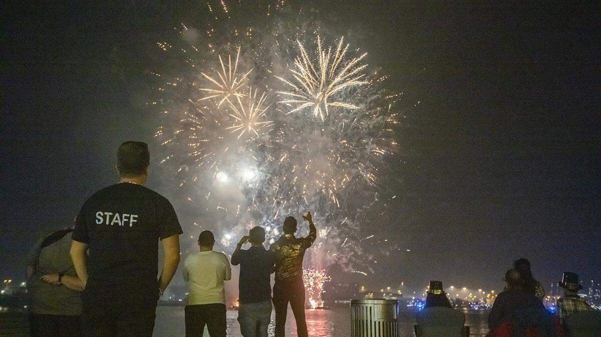 People pause to look at fireworks from different boats in Biscayne Bay during the New Year’s celebration in Bayfront Park in downtown Miami in this Dec. 31, 2024, archive photo.