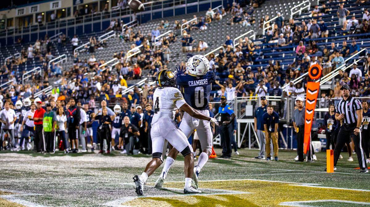 Florida International University wide receiver Tyrese Chambers (0) catches the ball for a touchdown while covered by Bryant University defensive back Lake Ellis (4) during overtime of an NCAA Conference USA football game at Riccardo Silva Stadium in Miami, Florida, on Thursday, September 1, 2022.