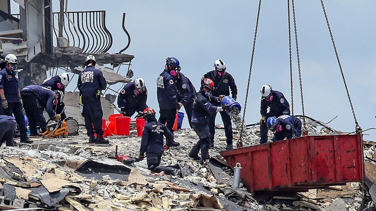 El equipo de Búsqueda y Rescate Urbano del Sur de la Florida busca entre los escombros de Champlain Towers South después que el edificio colapsó el 24 de junio de 2021.