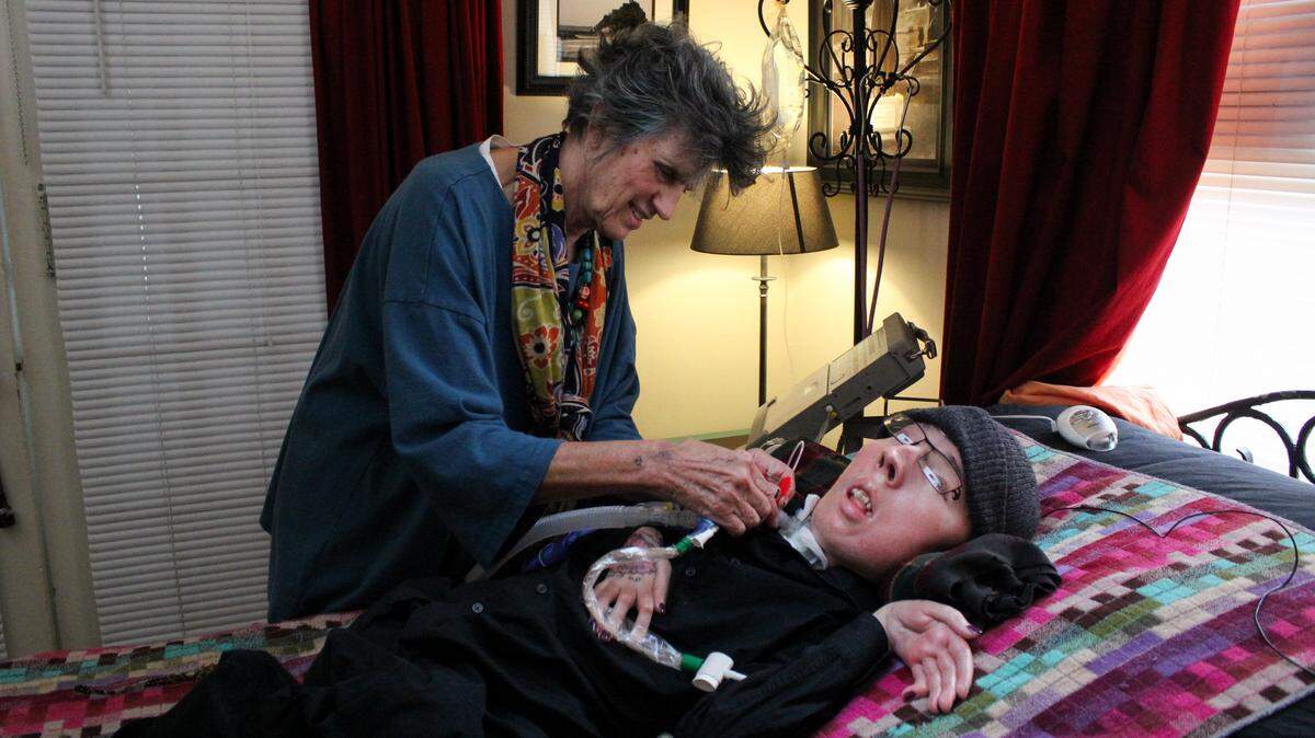 Karen Clay operates a medical ventilator to help her son Michael Phillips, 36, breathe. Michael has spinal muscular atrophy and is confined to his bed. He can breathe only with the aid of a machine. Here, they are photographed at their Tampa home July 19, 2017.