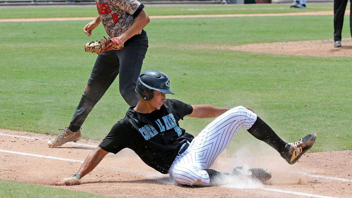 Coral Reef’s Shawn Perez slides into first base in the seventh inning of the FHSSA Finals Class 9A Division at CenturyLink Sports Complex - Hammond Stadium in Fort Myers, Florida, on Saturday, June, 1, 2019.