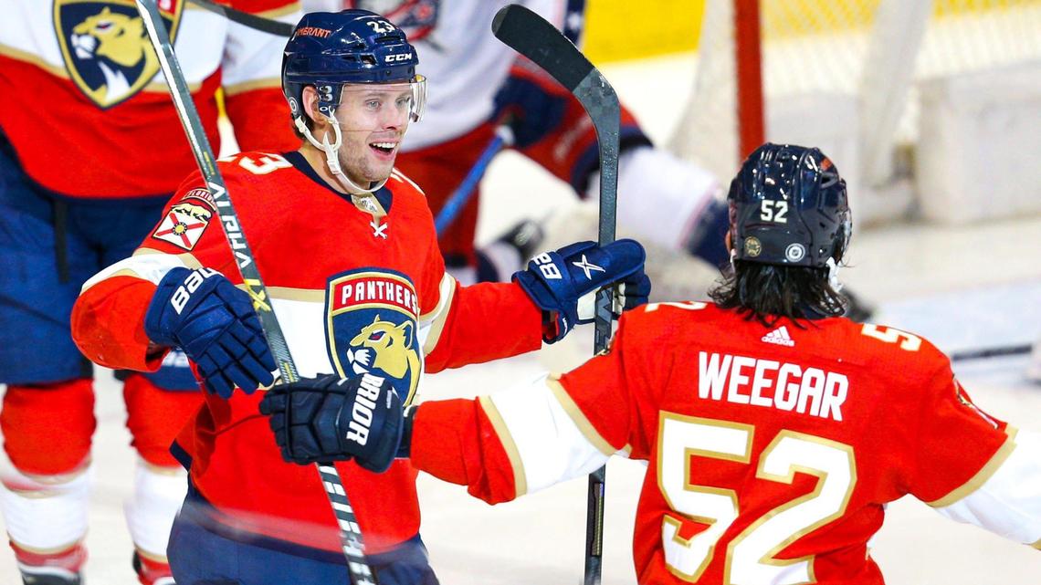 Florida Panthers center Carter Verhaeghe (16) celebrates with teammate MacKenzie Weegar (52) after scoring on Columbus Blue Jackets goalie Elvis Merzlikins (90) during the first period of an NHL game goalie FLA Live Arena in Sunrise, Florida, on Saturday, January 15, 2022.